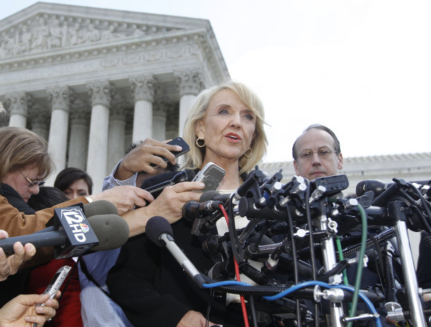 FILE - In this Wednesday, April 25, 2012 file photo, Arizona Gov. Jan Brewer speaks to reporters after the Supreme Court questioned Arizona's "show me your papers" immigration law in front of the Supreme Court in Washington. On Thursday, Sept. 6, 2012, Brewer's office said the most contentious section of Arizona's immigration law is expected to go into effect shortly. A spokesman says Brewer is pleased with a federal judge's decision on Wednesday, Sept. 5, 2012 to allow enforcement of the law. It enables officers, while enforcing other laws, to question the immigration status of those they suspect are in the country illegally. The National Immigration Law Center says it's considering "legal options" after the ruling. (AP Photo/Charles Dharapak)
