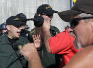 Police and union workers clash during a tense moment as union workers block a grain train in Longview, Wash., Wednesday, Sept. 7, 2011. Longshoremen blocked the train as part of an escalating dispute about labor at the EGT grain terminal at the Port of Longview.(AP Photo/Don Ryan)