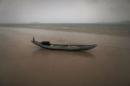 Fishing boat sits on a beach during a rain storm on the east coast of Natuna Besar