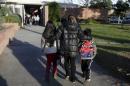A mother escorts her children on to the campus of Beethoven Street Elementary School in Los Angeles, California