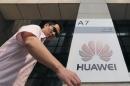 A man walks past a Huawei company logo outside the entrance of a Huawei office in Wuhan, Hubei province