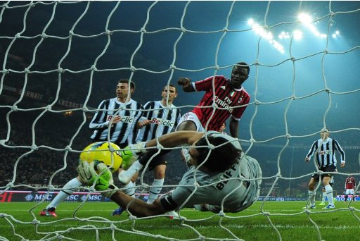 Juventus' goalkeeper Gianluigi Buffon grabs the ball in front of AC Milan's Sulley Muntari