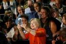 U.S. Democratic presidential nominee Hillary Clinton takes a selfie with supporters during a campaign rally in Kissimmee