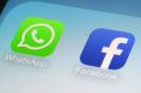 This Wednesday, Feb. 19, 2014 photo shows the WhatsApp and Facebook app icons on an iPhone in New York. On Wednesday the world's biggest social networking company, Facebook, announced it is buying mobile messaging service WhatsApp for up to $19 billion in cash and stock. (AP Photo/Patrick Sison)