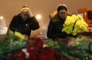 Women cry laying flowers outside the Volgograd main railway station in Volgograd, Russia, early Monday Dec. 30, 2013. Russian authorities ordered police to beef up security at train stations and other facilities across the country after a suicide bomber killed 14 people on a bus Monday in the southern city of Volgograd.It was the second deadly attack in two days on the city that lies just 400 miles (650 kilometers) from the site of the 2014 Winter Olympics. (AP Photo/Denis Tyrin)