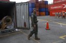A police officer walks next to a container holding a MiG-21 fighter jet engine from the seized North Korean-flagged ship Chong Chon Gang, at the Manzanillo Container Terminal in Colon