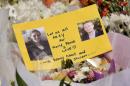 A card with photos of Katrina Dawson (L) and Tori Johnson, the two hostages killed during a fatal siege in the heart of Sydney's financial district, is seen at a makeshift memorial near the scene, on December 17, 2014