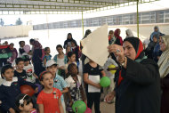 La asesora escolar Amal Suleiman el-Aroud quema un cartel con una foto de Moamar Gadafi en la escuela Al-Fayha en Trípoli, Libia, mientras los alumnos entonan lemas contra el líder prófugo el sábado 17 de septiembre del 2011 (AP Foto/Kim Gamel)
