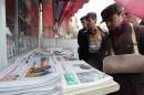 Iranians look at newspapers displayed outside a kiosk in Tehran, a day after a deal was reached on the country's nuclear programme, on November 24, 2013