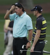 Phil Mickelson, left, chats with Brendan Steele on the second green during a practice round for the Masters golf tournament Tuesday, April 3, 2012, in Augusta, Ga. (AP Photo/Charlie Riedel)
