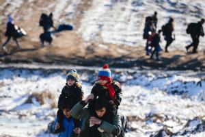Migrants and refugees walk through snow-covered fields&nbsp;&hellip;