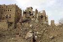 A man walks past houses damaged by Saudi-led airstrikes in Yemen's northwestern city of Saada