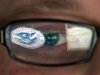 FILE - This Sept. 30, 2011 file photo shows a reflection of the Department of Homeland Security logo in the eyeglasses of a cybersecurity analyst at the watch and warning center of the Department of Homeland Security's secretive cyber defense facility in Idaho Falls, Idaho. The center is tasked with protecting the nation’s power, water and chemical plants, electrical grid and other facilities from cyber attacks. (AP Photo/Mark J. Terrill, File)