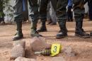Malian security forces stand guard over a grenade left behind at the site of a blast at La Terrasse bar restaurant in Bamako on March 7, 2015