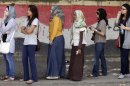 Egyptian women line up outside a polling station in Cairo, Egypt, Thursday, May 24, 2012. In a wide-open race that will define the nation's future political course, Egyptians voted Thursday on the second day of a landmark presidential election that will produce a successor to longtime authoritarian ruler Hosni Mubarak. The Egyptian flag is painted at background. (AP Photo/Amr Nabil)