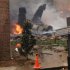The burning fuselage of an F/A-18 Hornet lies smoldering after crashing into a residential building in Virginia Beach, Va., Friday, April 6, 2012. The Navy did not immediately return telephone messages left by The Associated Press, but media reports indicate the two aviators were able to eject from the jet before it crashed. They were being treated for injuries that were not considered life threatening. (AP Photo/Kandice Angel)