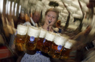 A waitress carries beer mugs in the Hofbraeuhaus tent after the opening of the famous Bavarian "Oktoberfest" beer festival in Munich, southern Germany, Saturday, Sept. 22, 2012. The world's largest beer festival, to be held from Sept. 22 to Oct. 7, 2012, will see some million visitors. (AP Photo/Matthias Schrader) EDS NOTE - SHUTTER SPEED CAUSING BLUR