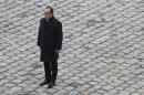 French President Francois Hollande stands at attention as he leads a ceremony to pay a national homage to the victims of the Paris attacks at Les Invalides monument in Paris