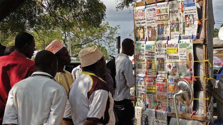 Locals look at newspaper headlines in Stone Town on the Indian Ocean island of Zanzibar on August 9, 2013