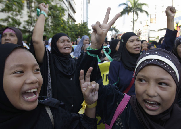 Filipino Muslim girls flash the peace sign during a rally in support of a preliminary peace agreement between the government and the nation's largest Muslim rebel group outside the Malacanang presidential palace in Manila, Philippines, on Sunday Oct. 14, 2012. About 200 Muslim rebels led by their elusive chief arrived in the Philippine capital on Sunday for the signing of a preliminary peace pact aimed at ending one of Asia's longest-running insurgencies. (AP Photo/Aaron Favila)