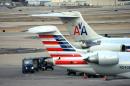 FILE - In this Dec. 2013 file photo crews work around two American Airlines jets in St. Louis. A deaf couple is upset over a note that an American Airlines employee attached to a bag misplaced by the airline that was delivered with a handwritten note reading, 