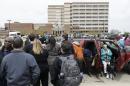 People stand outside a Veterans Affairs hospital after they were evacuated, Monday, May 5, 2014, in Dayton, Ohio. A city official says a suspect is in police custody after a shooting at the Veterans Affairs hospital in Ohio that left one person with a minor injury. (AP Photo/Al Behrman)