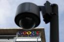 The Google logo is seen on the top of its China headquarters building, behind a road surveillance camera in Beijing