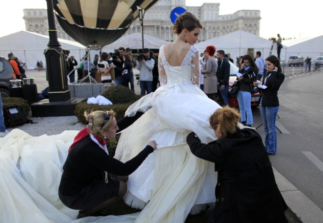 Aides arrange the wedding dress with the longest train in the world during a Guinness World Record attempt in Bucharest
