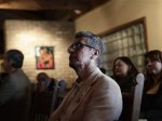 A man watches along with others as President Barack Obama speaks about immigration reform on a television monitor at a restaurant in Phoenix