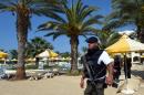 A Tunisian security member stands next to a swimming pool at the resort town of Sousse on June 26, 2015, following a shooting attack