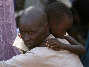 An internally displaced man holds his son inside UNMIS&nbsp;&hellip;