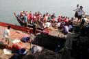 This image provided by DVB shows survivors who were saved after their ferry capsized near Kyauk Phyu port, Myanmar, on Saturday, March 14, 2015. A crowded double-decker ferry capsized in northwestern Myanmar after being slammed by huge waves, killing at least 21 people with nearly 50 others missing, officials said Saturday. (AP Photo/DVB) MANDATORY CREDIT