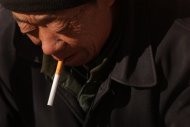 Homem fuma cigarro em Pequim, em dezembro de 2011