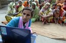 In this Sept. 30, 2012 photo, Sathi Akhtar, a 29-year-old Bangladeshi woman known as Tattahakallayani or Info Lady shows a 15-minute video played in a laptop at one of their usual weekly meetings at Saghata, a remote impoverished farming village in Gaibandha district, 120 miles (192 kilometers) north of capital Dhaka, Bangladesh. Dozens of 