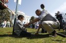 U.S. President Obama consoles Donovan Frazier, 5, who lost during his easter egg roll event during in the 135th annual Easter Egg Roll on the South Lawn of the White House in Washington