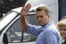 Russian opposition leader Alexei Navalny waves as he heads for questioning at the headquarters of the Russian Investigation committee in Moscow, Russia, Tuesday June 12, 2012. Russia's top investigation agency has summoned several key opposition figures for questioning in an apparent bid to disrupt the first massive protest against President Vladimir Putin since his inauguration for a third term. (AP Photo/Mikhail Metzel)