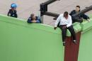 A man threatening suicide sits on a building ledge in New York's Times Square area