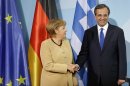 FILE - In this Aug. 24, 2012 file photo German Chancellor Angela Merkel, left, and Prime Minister of Greece Antonis Samaras, right, shake hands after a joint news conference as part of a meeting at the chancellery in Berlin, Germany. Merkel wants the Greeks to keep the euro. Her vice chancellor says it wouldn't be so bad if they abandoned the common currency. Another ally says Greece should leave the euro club within months. (AP Photo/Michael Sohn, File)