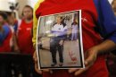 Supporter of Venezuelan President Hugo Chavez holds a picture of him, as she attends a mass to pray for Chavez's health in Caracas