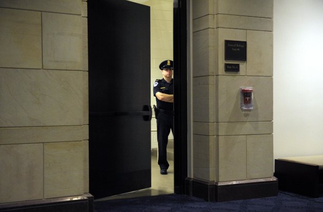 A Capitol Hill Police officer guards a staircase near the hearing room where former CIA Director David Petraeus is testifing before the House Intelligence committee on the Sept. 11, 2012 attack in Libya, on Capitol Hill in Washington, Friday, Nov. 16, 2012. (AP Photo/Cliff Owen)