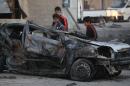 Iraqi children inspect the aftermath of a car bomb explosion in the Sadr City district of Baghdad, on November 9, 2014