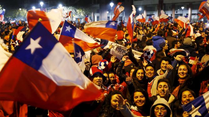 Chilean fans wave national flags as they celebrate Chile&#39;s victory over Peru in their Copa America 2015 semi-final soccer match in Concepcion