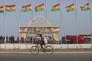 A man rides a bicycle past Ghanian flags flown at half mast to honor late Ghanian President, John Evans Atta Mills at the independence square in Accra, Ghana, Thursday, Aug.9, 2012. The rumors started to swirl around Ghana in June: President John Atta Mills was ill, maybe too sick to seek re-election, and he was going abroad to seek medical treatment. Some radio stations went so far as to prematurely report his death. Eager to deny the speculation, Atta Mills jogged at the airport upon his return in a display of his vigor. The following month, though, the 68-year-old was dead. Many lined up in the capital, Accra, where his body was laid in a casket draped in the national colors of red, yellow and green on Wednesday to pay their respects before his burial Friday. (AP Photo/Sunday Alamba)