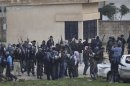 Members of the Free Syrian Army gather as gunfire is heard between them and the armed Kurds of The Kurdish Democratic Union Party (PYD) in the northern Syrian town of Ras al-Ain