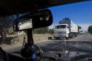 Trucks move towards a border control point with Ukraine in the Russian town of Donetsk, Rostov-on-Don region, Russia, Friday, Aug. 22, 2014. The first trucks of the Russian aid convoy crossed the Ukrainian inspection zone Friday morning. (AP Photo/Pavel Golovkin)