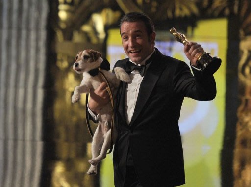 Jean Dujardin pose avec son Oscar de meilleur acteur et le chien Uggie le 26 février 2012 à Hollywood