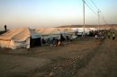A file picture taken on August 27, 2013, shows Kurd refugees from Syria sitting outside tents provided by the UN High Commission for Refugees (UNHCR) at the Quru Gusik refugee camp in northern Iraq