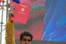 Venezuela's President Nicolas Maduro, left, holds up the "anti-imperialist" law given to him by National Assembly President Diosdado Cabello, right, during a rally outside Miraflores presidential palace in Caracas, Venezuela, Sunday, March 15, 2015. Venezuela's parliament has approved a law giving Maduro the power to legislate by decree for nine months in the face of what he describes as threats by the U.S. government. (AP Photo/Fernando Llano)