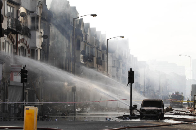 Firefighters spray water onto building set on fire by rioters last night in Croydon, south London, Tuesday, Aug. 9, 2011. A wave of violence and looting raged across London and spread to three other m