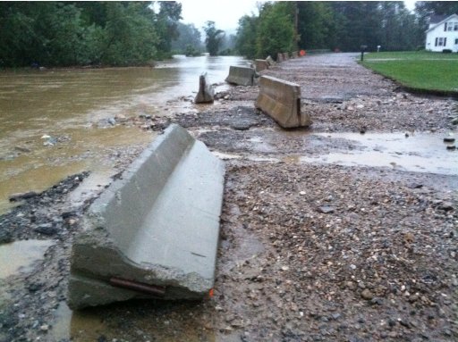 In this photo provided by Sarah Jones, Jersey barriers strewn along the historic Silk Road after flood waters from Tropical Storm Irene flooded the Walloomsac River in Bennington Vt., Sunday, Aug. 28, 2011. The flooding of the Walloomsac River was responsible for damage to at least one house and the loss of a car in Woodford, Vt. (AP Photo/Sarah Jones)